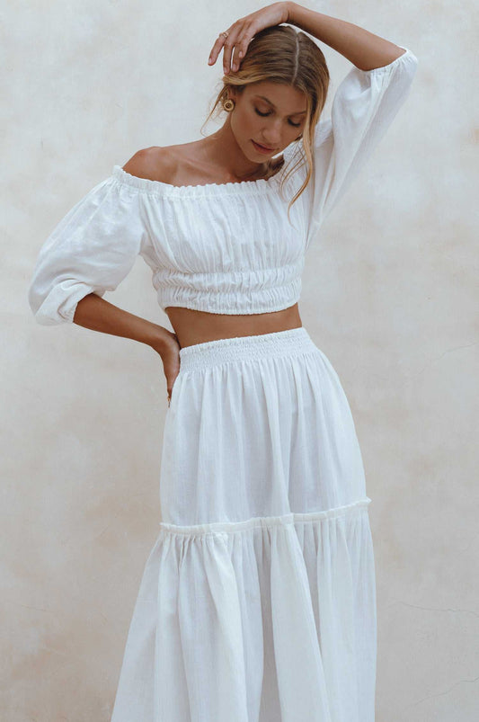 Woman wearing white Annabelle maxi skirt with elasticated waistband and tiered linen fabric in boho style